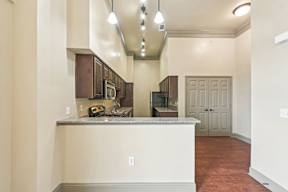 A kitchen with a white counter and brown cabinets.