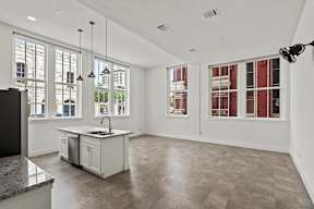 A modern kitchen with a large island and a flat screen TV.