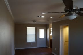 an empty room with a ceiling fan and a door