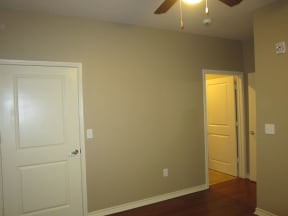 an empty room with a ceiling fan and a door that is open