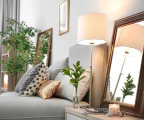 a living room with a couch and a table with a vase with a plant on it