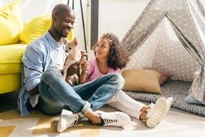 young couple sitting on the floor with their dog