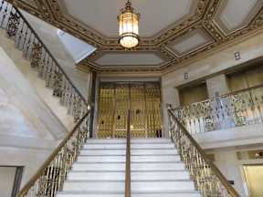 A staircase with a metal railing and a light hanging from the ceiling.