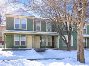 A green house with a tree in front of it at Meeker Commons Apartments, Colorado