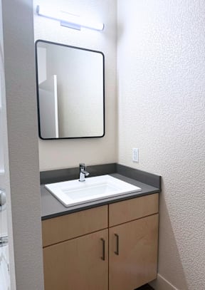 A bathroom with a sink and mirror.