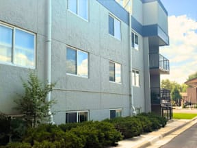 A modern apartment building with a balcony on the second floor.