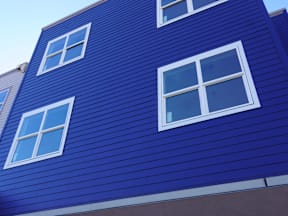 A blue building with white windows at Gateway Village Apartments, Fort Morgan, CO