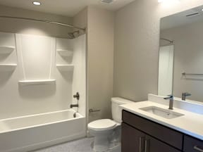A white bathroom with a toilet, sink, and bathtub.