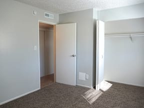 A room with a carpeted floor and a white door at Mountain Terrace Apartments, Colorado.