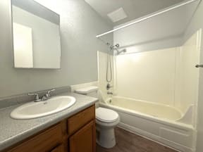 A bathroom with a white tub, sink, and toilet at Mountain Terrace Apartments, Westminster, Colorado.