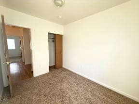 A room with a carpeted floor and two doors.