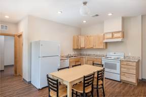A kitchen with a table and chairs in the middle of the room.