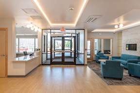 A modern office lobby with a reception desk and a waiting area.