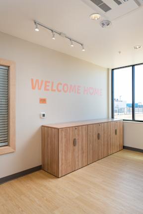 A reception desk with a sign that says "Welcome Home" on the wall behind it.