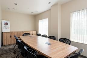 A conference room with a long table and chairs.