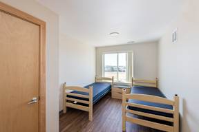 A room with two beds and a door.