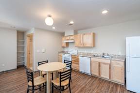 A kitchen with a table and chairs.
