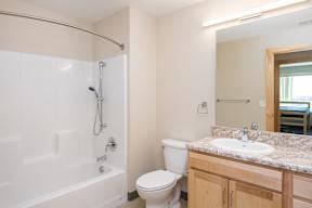 A bathroom with a toilet, sink, and shower.