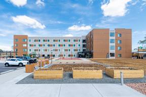 A modern building with a parking lot in front.