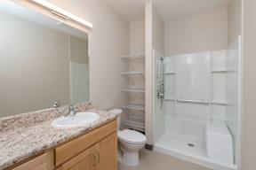 A bathroom with a sink, toilet, and shower.
