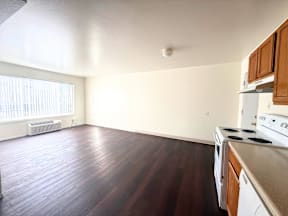 A kitchen with white appliances and wooden floors at Townview Plaza Apartments, Denver, Colorado.