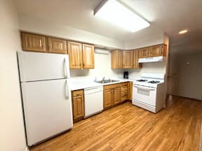A kitchen with wooden cabinets and white appliances.