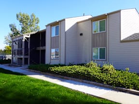 A building with a grey siding and a white roof at Gateway Village Apartments, Fort Morgan, CO 80701