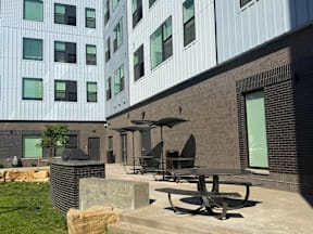 A modern building with a patio area in front.