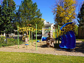 A playground with a blue slide and yellow equipment at Garden Court Apartments, Denver, Colorado