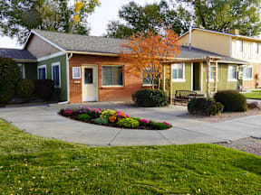 A small house with a brown door and a white door at Willow Grove Apartments, Clifton, CO.