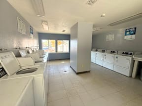 A laundromat with washers and dryers lined up at Grand Manor Apartments, Colorado, 81501