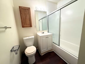 A white toilet sits next to a white sink in a small bathroom at Townview Plaza Apartments, Denver.