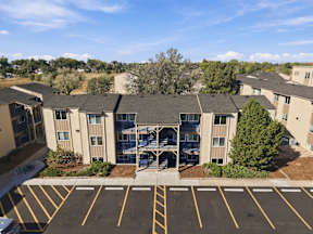A parking lot in front of a building with a yellow line at Gateway Village Apartments in Fort Morgan, CO, 80701