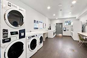 A laundromat with a row of washers and dryers at Gateway Village Apartments in Fort Morgan, CO, 80701