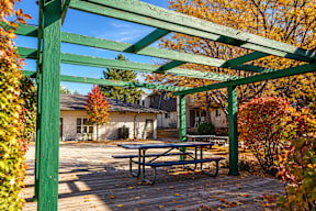 A green wooden pergola with a picnic table underneath it t Mountain Terrace Apartments , Westminster, CO, 80031