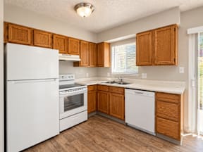 A kitchen with white appliances and wooden cabinets t Mountain Terrace Apartments , Westminster, CO, 80031