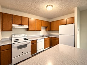 A kitchen with white appliances and wooden cabinets.