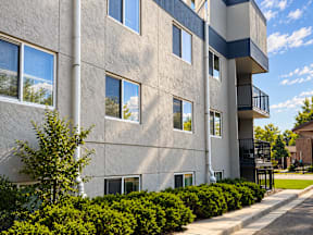 A grey building with a balcony on the second floor.