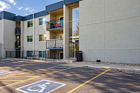 A parking lot with a handicap parking space in front of a building.