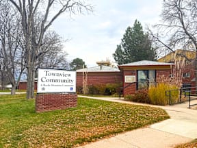 A sign for Townview Community in front of a building. at Townview Plaza Apartments , Colorado, 80204