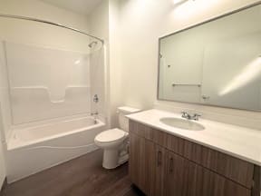 A white bathroom with a toilet, sink, and bathtub.