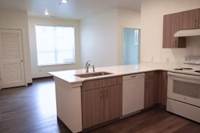 A kitchen with a white counter top and wooden cabinets.