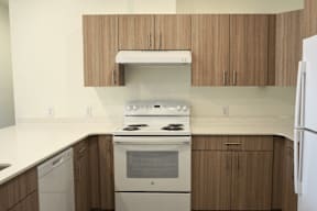 A white stove top oven with a white refrigerator in a kitchen.