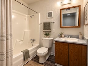 A bathroom with a toilet, sink, and shower.