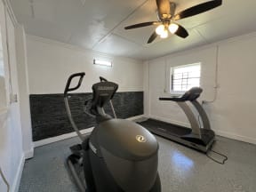 a gym with a exercise bike and a ceiling fan at Ann Street Lofts, Mobile