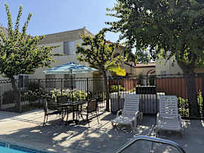 A poolside area with chairs and a table.
