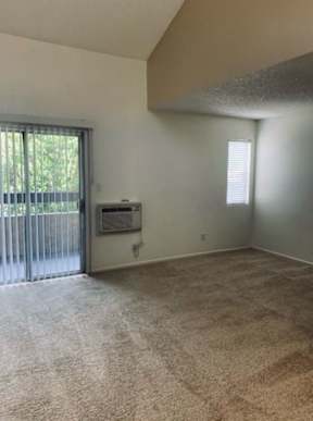 A room with a window and a sliding glass door.