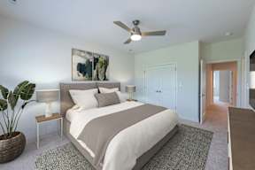 A bedroom with a large bed and a ceiling fan.