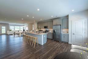 A modern kitchen with wooden floors and a large island.