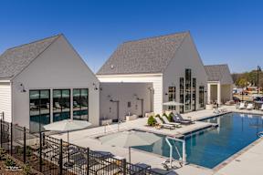 A large white house with a pool in front.